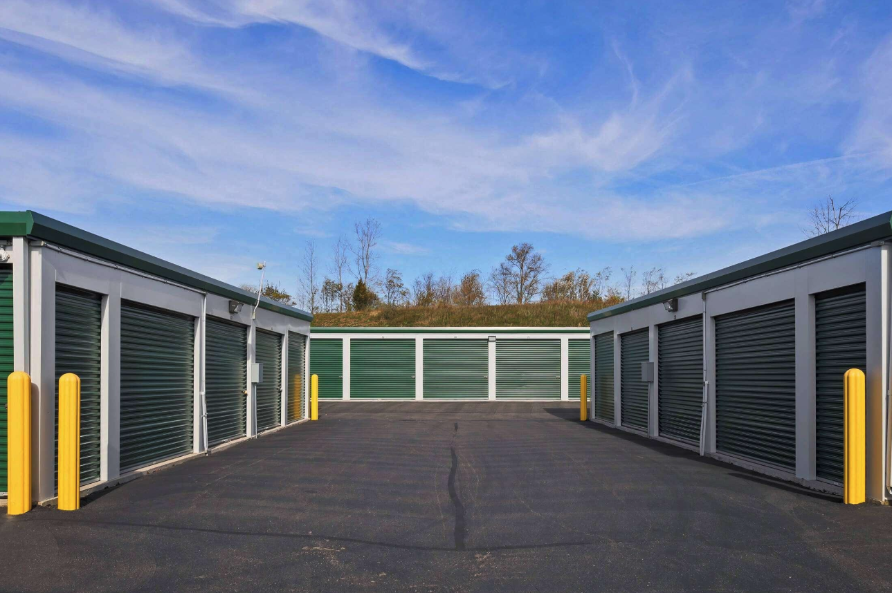 Drive-up storage units with green roll-up doors at TMG Mini Storage in Sarcoxie, Missouri